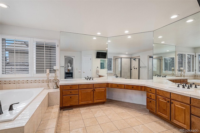 full bathroom with tile patterned floors, two vanities, a stall shower, and a sink