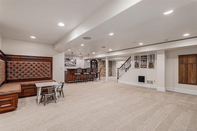 interior space with a bar, recessed lighting, and light carpet