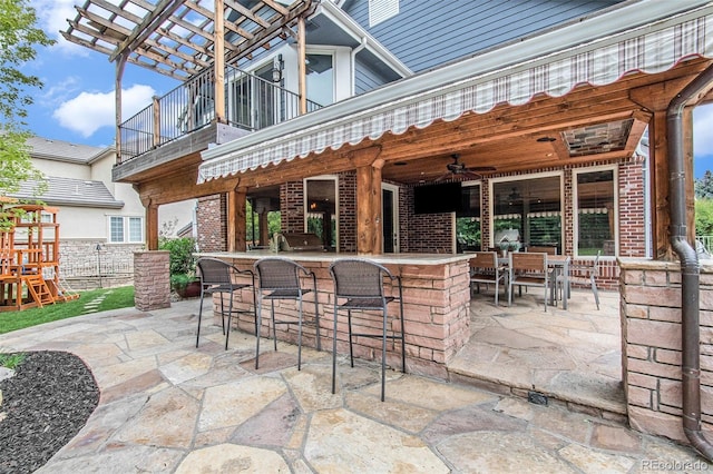 view of patio featuring a balcony and exterior bar