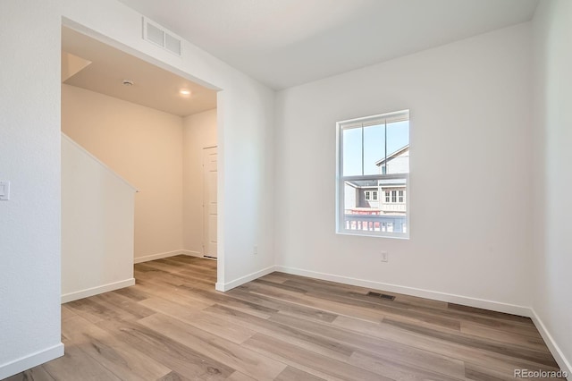 unfurnished room with light wood-type flooring and baseboards