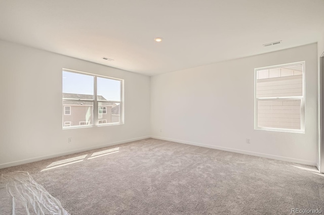 carpeted empty room featuring baseboards