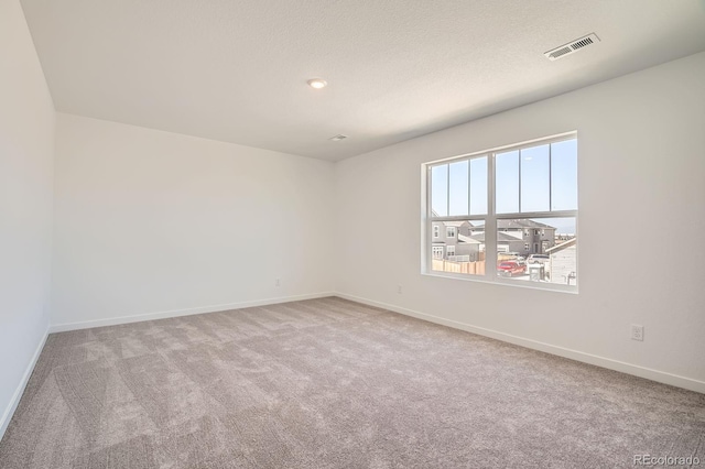 carpeted empty room featuring baseboards