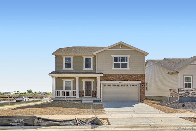 craftsman-style home featuring stone siding, covered porch, concrete driveway, and a garage