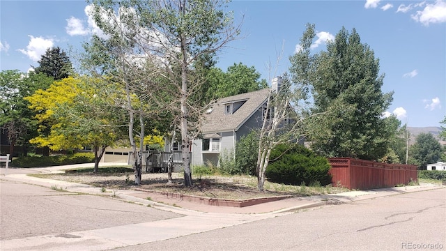 5298 Pony Creek Cir, Colorado Springs, CO 80919 - view of property hidden behind natural elements with a chimney, a garage, and driveway