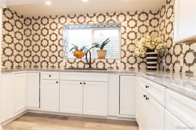 5298 Pony Creek Cir, Colorado Springs, CO 80919 - kitchen featuring wallpapered walls, white cabinets, tasteful backsplash, light wood-style floors, and recessed lighting