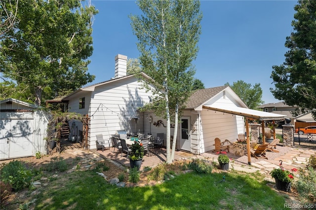 5298 Pony Creek Cir, Colorado Springs, CO 80919 - rear view of house featuring a patio, a storage shed, an outdoor living space with a fire pit, and a chimney