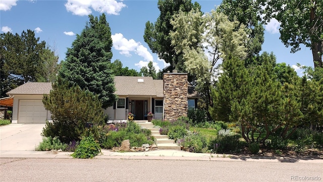 5298 Pony Creek Cir, Colorado Springs, CO 80919 - view of front of home featuring driveway, a garage, and a chimney