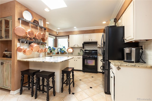 5298 Pony Creek Cir, Colorado Springs, CO 80919 - kitchen featuring black range with gas cooktop, under cabinet range hood, ornamental molding, decorative backsplash, and a breakfast bar