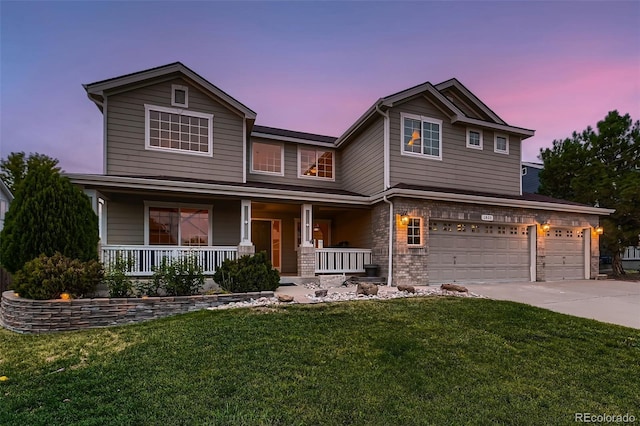 view of front of house featuring a yard, a porch, and a garage