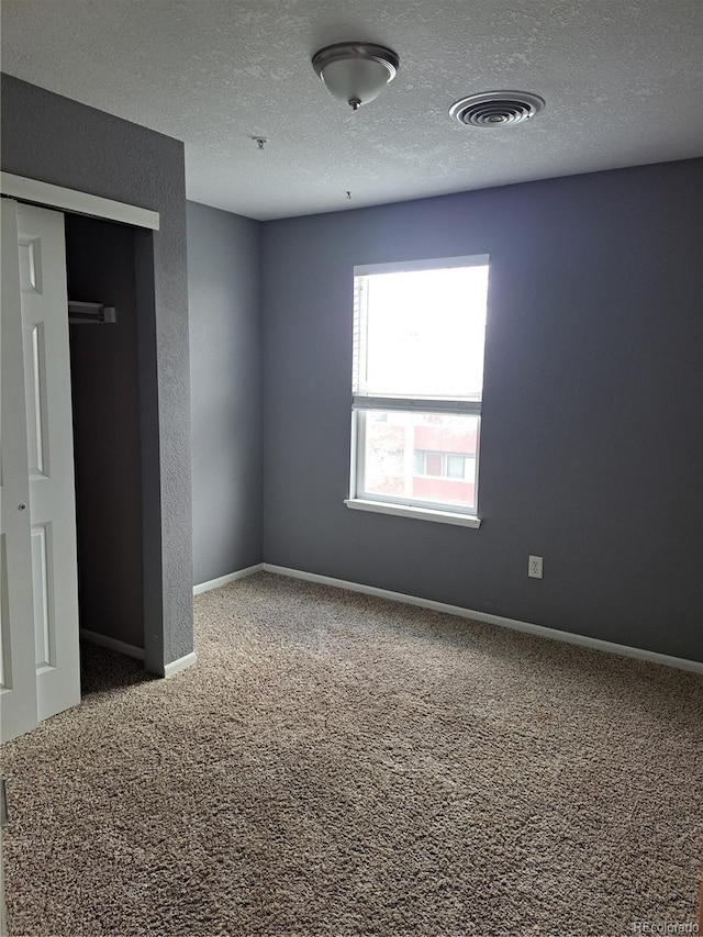 2226 W Elizabeth St Unit C304, Fort Collins, CO 80521 - unfurnished bedroom featuring carpet, a textured ceiling, a closet, and baseboards