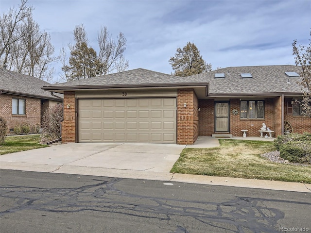 view of front facade with brick siding, a shingled roof, concrete driveway, a front yard, and an attached garage