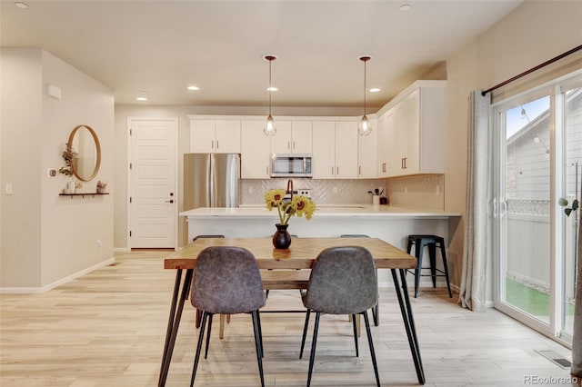 3765 W 88th Ct, Westminster, CO 80031 - kitchen with stainless steel appliances, light countertops, tasteful backsplash, light wood-type flooring, and a peninsula