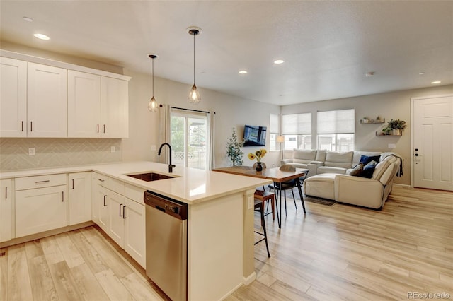 3765 W 88th Ct, Westminster, CO 80031 - kitchen with dishwasher, a sink, light wood finished floors, tasteful backsplash, and a peninsula