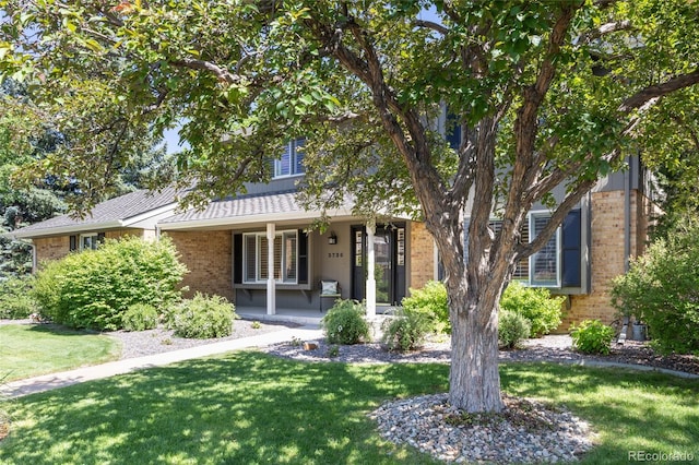 3726 E Nichols Ave, Centennial, CO 80122 - view of front of house featuring brick siding, a front lawn, and covered porch