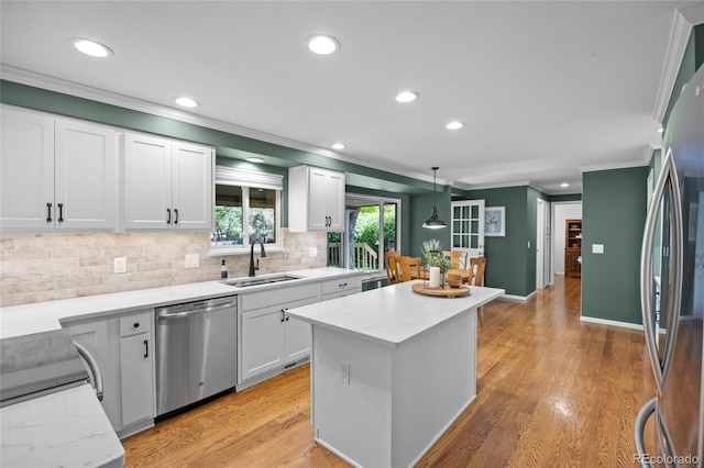 3726 E Nichols Ave, Centennial, CO 80122 - kitchen featuring stainless steel appliances, a sink, crown molding, a kitchen island, and backsplash