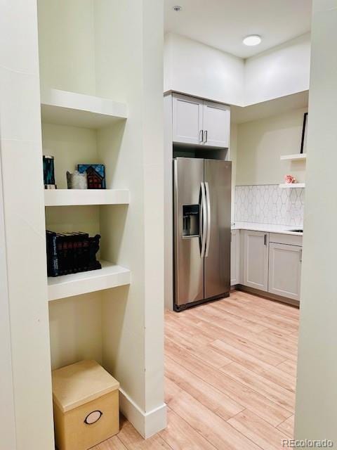 2876 W 53rd Ave Unit 305, Denver, CO 80221 - kitchen with stainless steel refrigerator with ice dispenser, light wood-type flooring, tasteful backsplash, open shelves, and light countertops