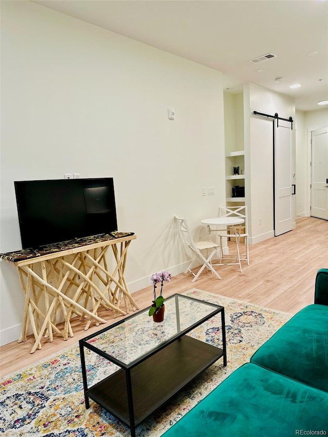 2876 W 53rd Ave Unit 305, Denver, CO 80221 - living area with a barn door, baseboards, and wood finished floors