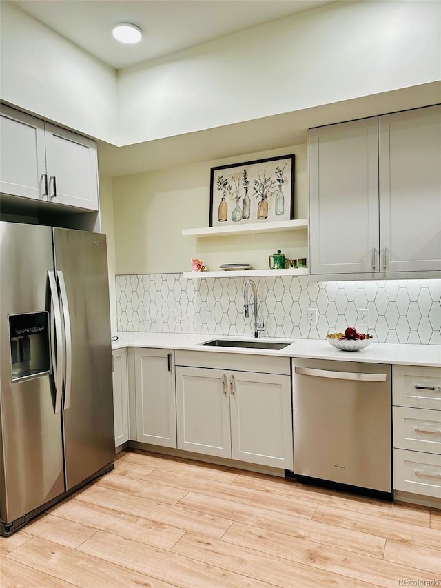 2876 W 53rd Ave Unit 305, Denver, CO 80221 - kitchen featuring stainless steel appliances, a sink, light countertops, and open shelves