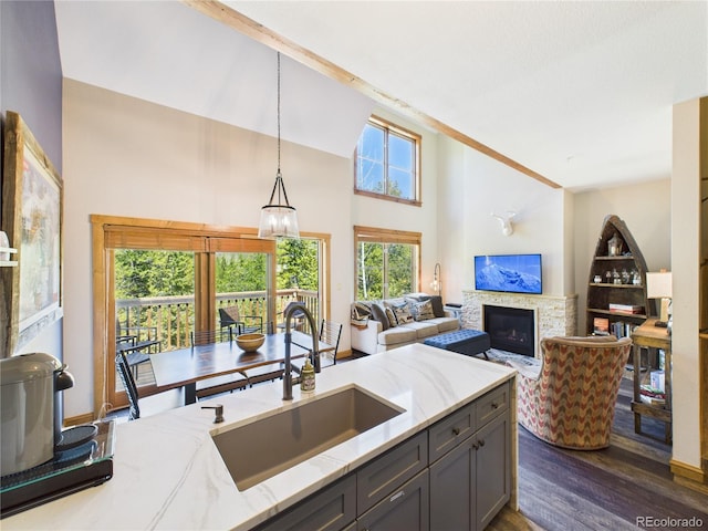 27 Lake Ridge Cir Unit 1842, Dillon, CO 80435 - kitchen with a sink, light stone counters, dark wood finished floors, gray cabinets, and a fireplace