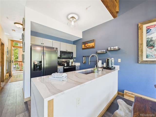 27 Lake Ridge Cir Unit 1842, Dillon, CO 80435 - kitchen featuring black appliances, a sink, a peninsula, white cabinets, and wood finished floors