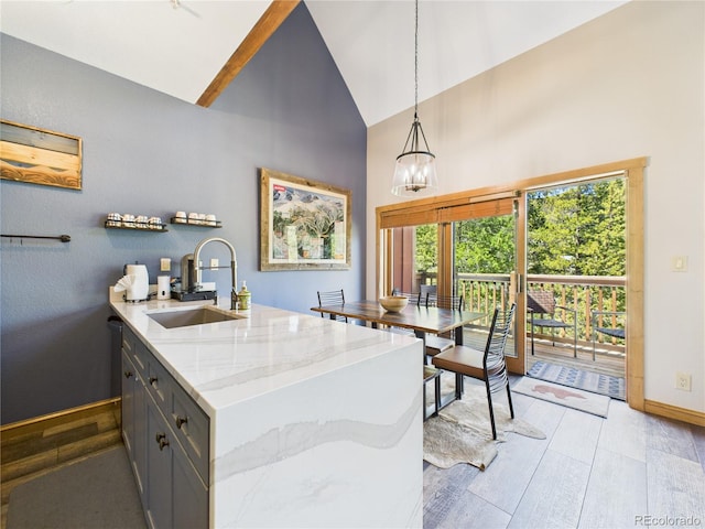 27 Lake Ridge Cir Unit 1842, Dillon, CO 80435 - kitchen featuring a sink, high vaulted ceiling, baseboards, light stone countertops, and light wood-type flooring