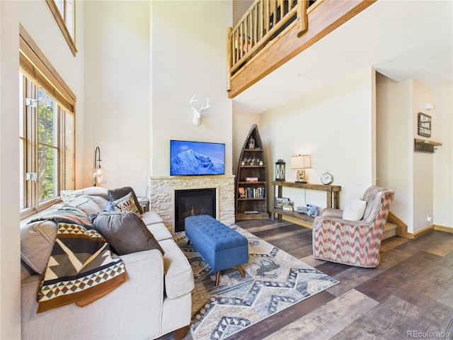 27 Lake Ridge Cir Unit 1842, Dillon, CO 80435 - living area with wood finished floors, a stone fireplace, a towering ceiling, and baseboards