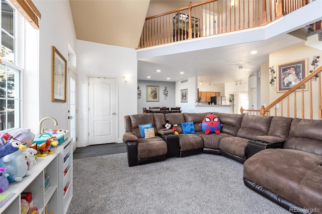 carpeted living room featuring stairs, a high ceiling, visible vents, and recessed lighting