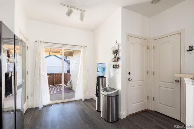 interior space with baseboards, dark wood finished floors, and track lighting