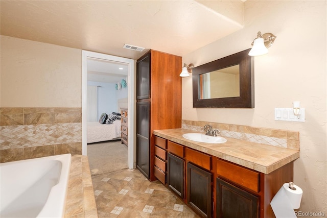 ensuite bathroom with a garden tub, visible vents, connected bathroom, and vanity