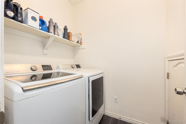 laundry area featuring dark wood-type flooring, laundry area, baseboards, and separate washer and dryer