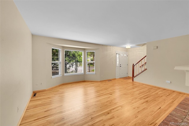 9930 W Progress Pl, Littleton, CO 80123 - unfurnished living room featuring wood finished floors, stairway, and baseboards