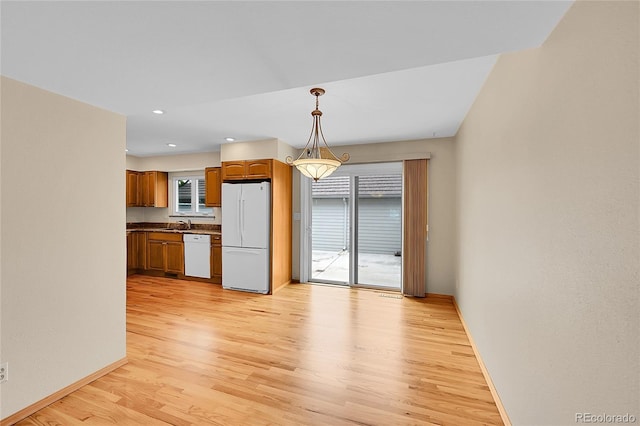 9930 W Progress Pl, Littleton, CO 80123 - kitchen featuring white appliances, light wood-style floors, baseboards, dark countertops, and decorative light fixtures
