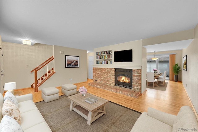 9930 W Progress Pl, Littleton, CO 80123 - living area featuring wood finished floors, stairway, and a brick fireplace