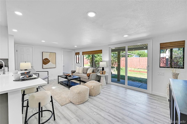 living room featuring a textured ceiling and light wood-type flooring