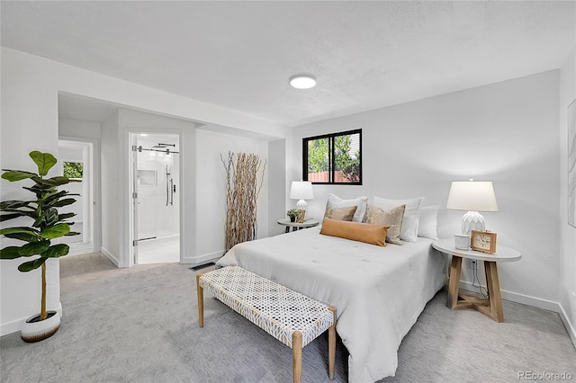 carpeted bedroom featuring ensuite bath