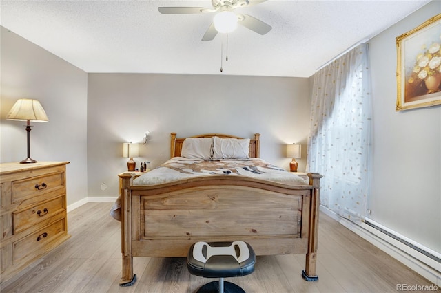 bedroom featuring ceiling fan, light hardwood / wood-style flooring, a baseboard radiator, and a textured ceiling