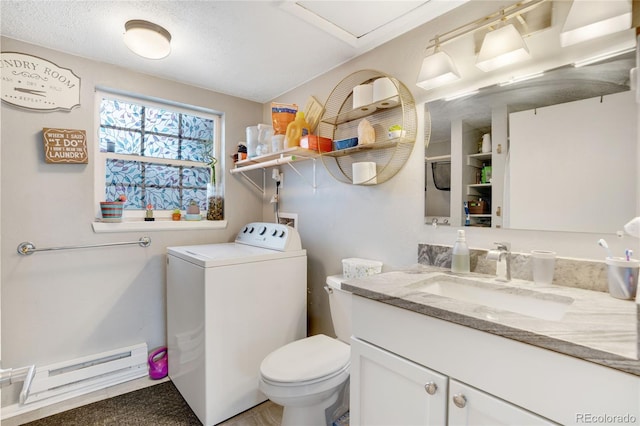 bathroom with toilet, a textured ceiling, washer / clothes dryer, vanity, and a baseboard heating unit