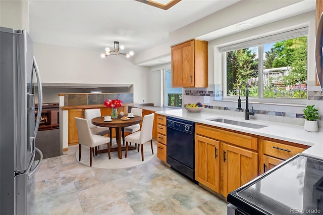 7681 S Jellison St, Littleton, CO 80127 - kitchen with black appliances, a chandelier, backsplash, light countertops, and brown cabinetry