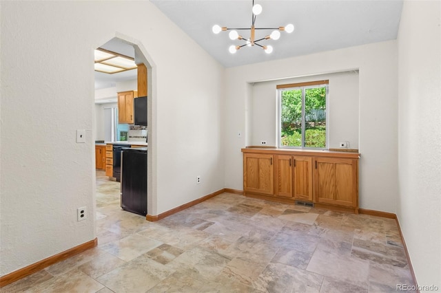 7681 S Jellison St, Littleton, CO 80127 - spare room with stone finish flooring, arched walkways, and a chandelier