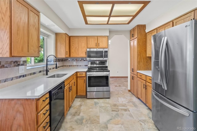 7681 S Jellison St, Littleton, CO 80127 - kitchen featuring appliances with stainless steel finishes, decorative backsplash, light countertops, stone finish flooring, and brown cabinetry