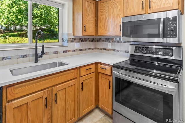 7681 S Jellison St, Littleton, CO 80127 - kitchen with appliances with stainless steel finishes, light countertops, decorative backsplash, and brown cabinetry
