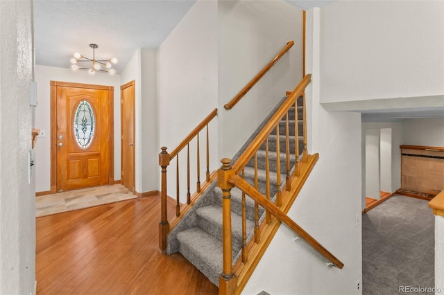 7681 S Jellison St, Littleton, CO 80127 - foyer entrance featuring wood finished floors, a chandelier, and stairway