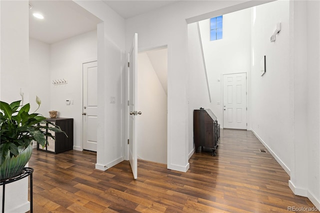 corridor with dark hardwood / wood-style flooring