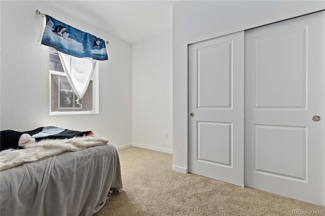 bedroom with light carpet and a closet