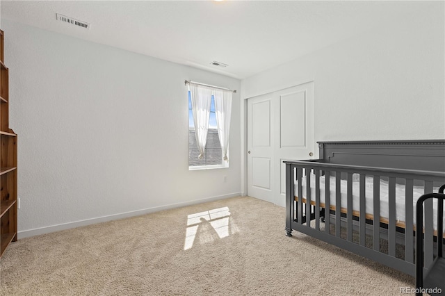 carpeted bedroom with a nursery area