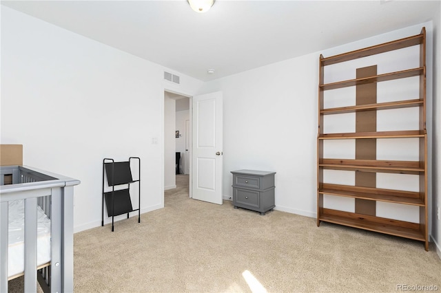 carpeted bedroom featuring a crib