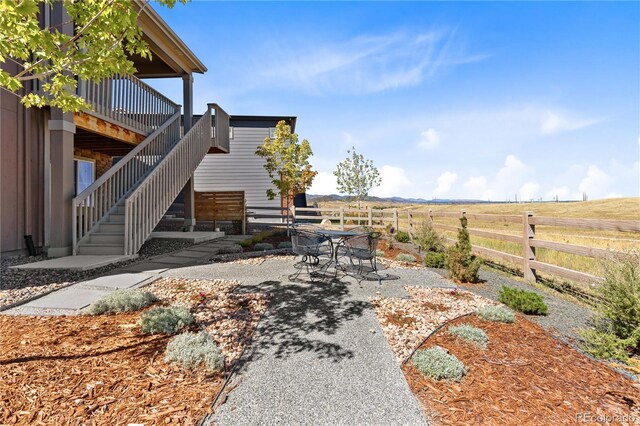 view of yard with a wooden deck and a rural view