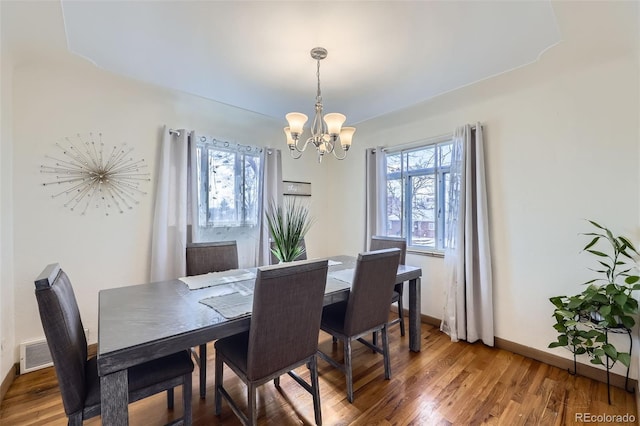 dining room featuring dark hardwood / wood-style flooring, a chandelier, and a wealth of natural light