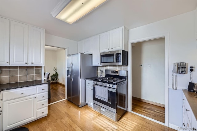 kitchen with white cabinetry, appliances with stainless steel finishes, and light hardwood / wood-style floors