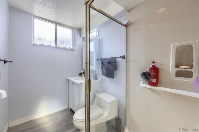 bathroom with walk in shower, toilet, a textured ceiling, vanity, and hardwood / wood-style floors